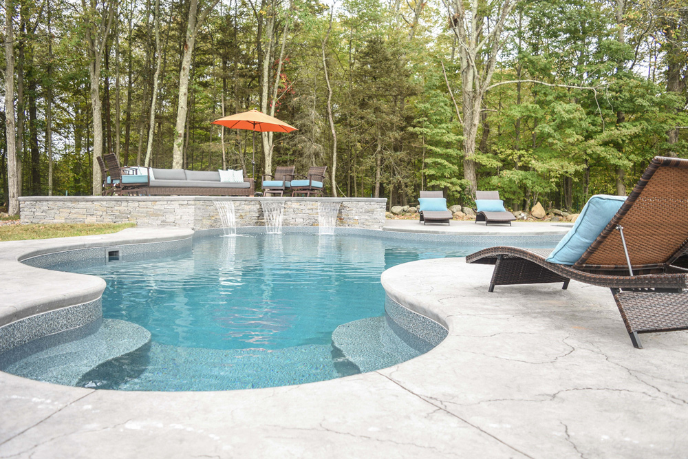 This is a photo of a custom in-ground swimming pool with chairs around it.