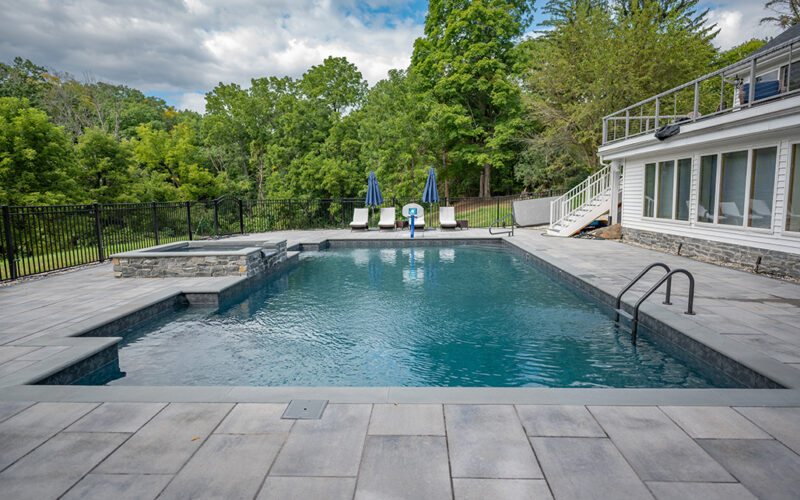 Custom Inground Pool Installed By Majestic Pools With Outdoor Lounge Chairs And Hot Tub